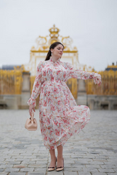 a lady in a silk pink floral printed dress with long sleeves